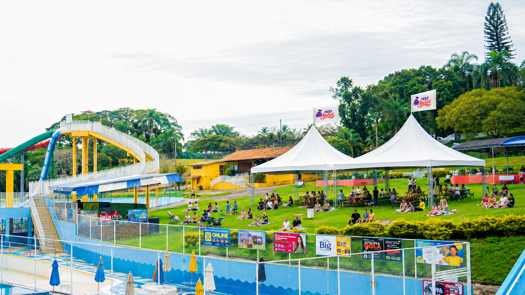Clube Plêiades com tendas do Fest Music, escorregador aquático e público no gramado